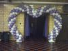 Heart arch spanning a double door entrance to a wedding reception.