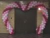 Huge heart-shaped arch spanning a double door entrance to a Valentine's Day dance.